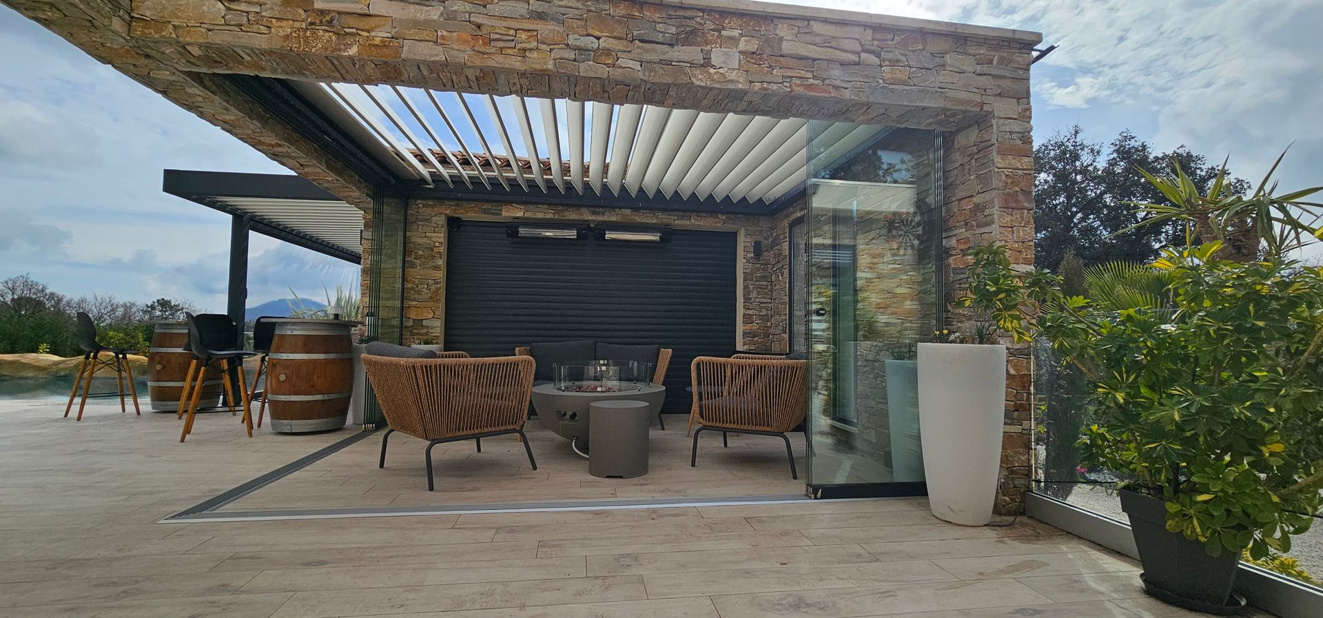 Terrasse extérieure avec sièges sous une pergola.