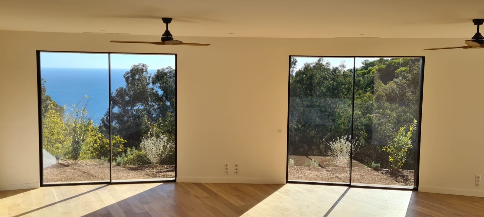 Deux baies vitrées en aluminum donnant sur un jardin.