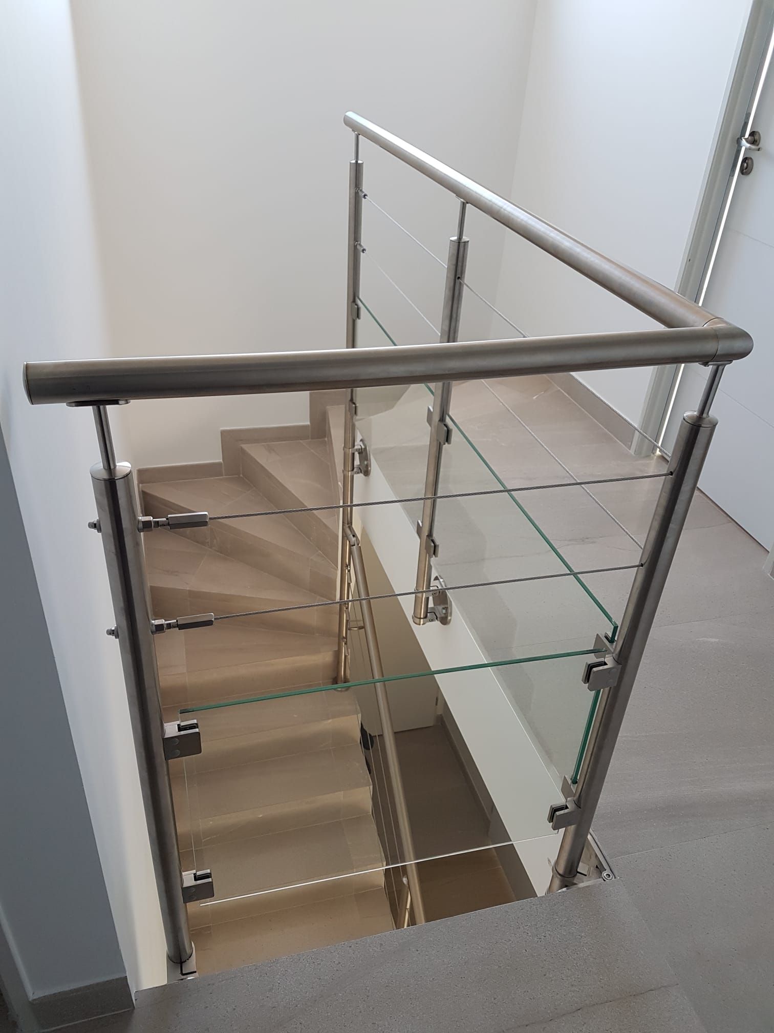 Rambarde d'escalier en acier inoxydable et verre.