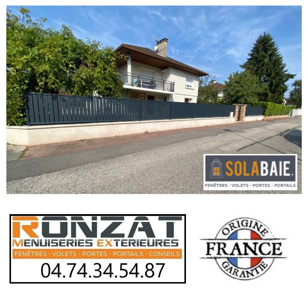 Clôture grise devant une maison, avec les logos SOLABAI, RÜNZAT et « ORIGINE FRANCE GARANTIE ».
