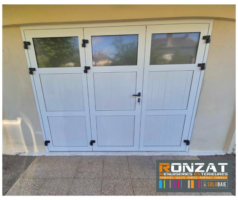 Portes de garage blanches avec panneaux de verre et quincaillerie noire.