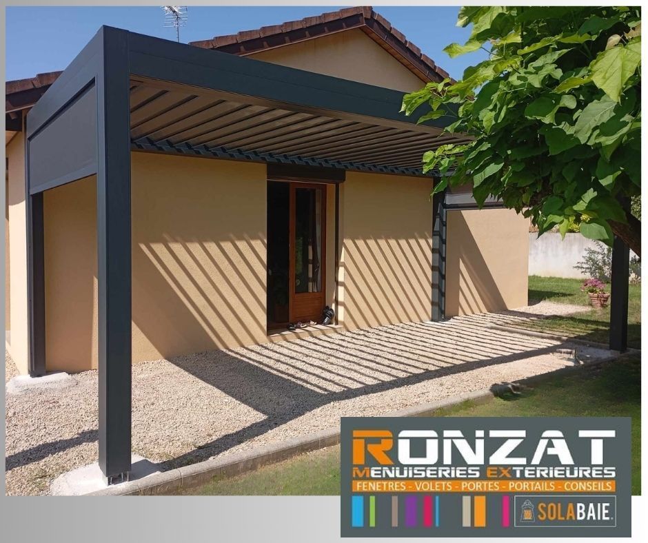 Une pergola noire ombrage une terrasse, projetant des ombres rayées sur le gravier. Façade du bâtiment en arrière-plan.