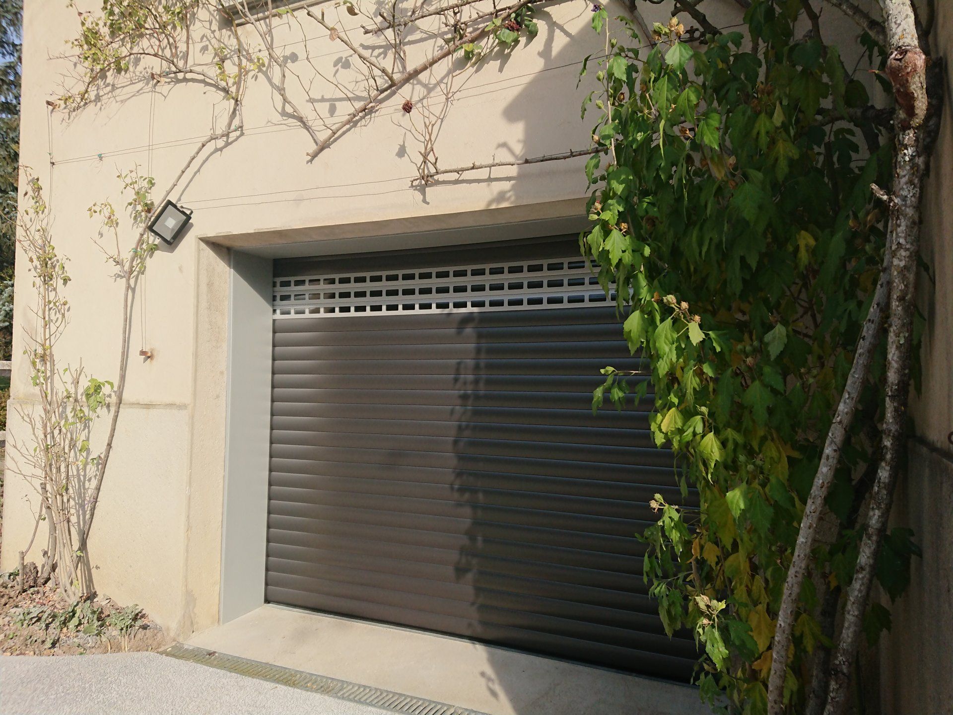Deux portes de garage brunes, dont une ouverte. Les logos des entreprises et les échantillons de couleurs sont indiqués ci-dessous.