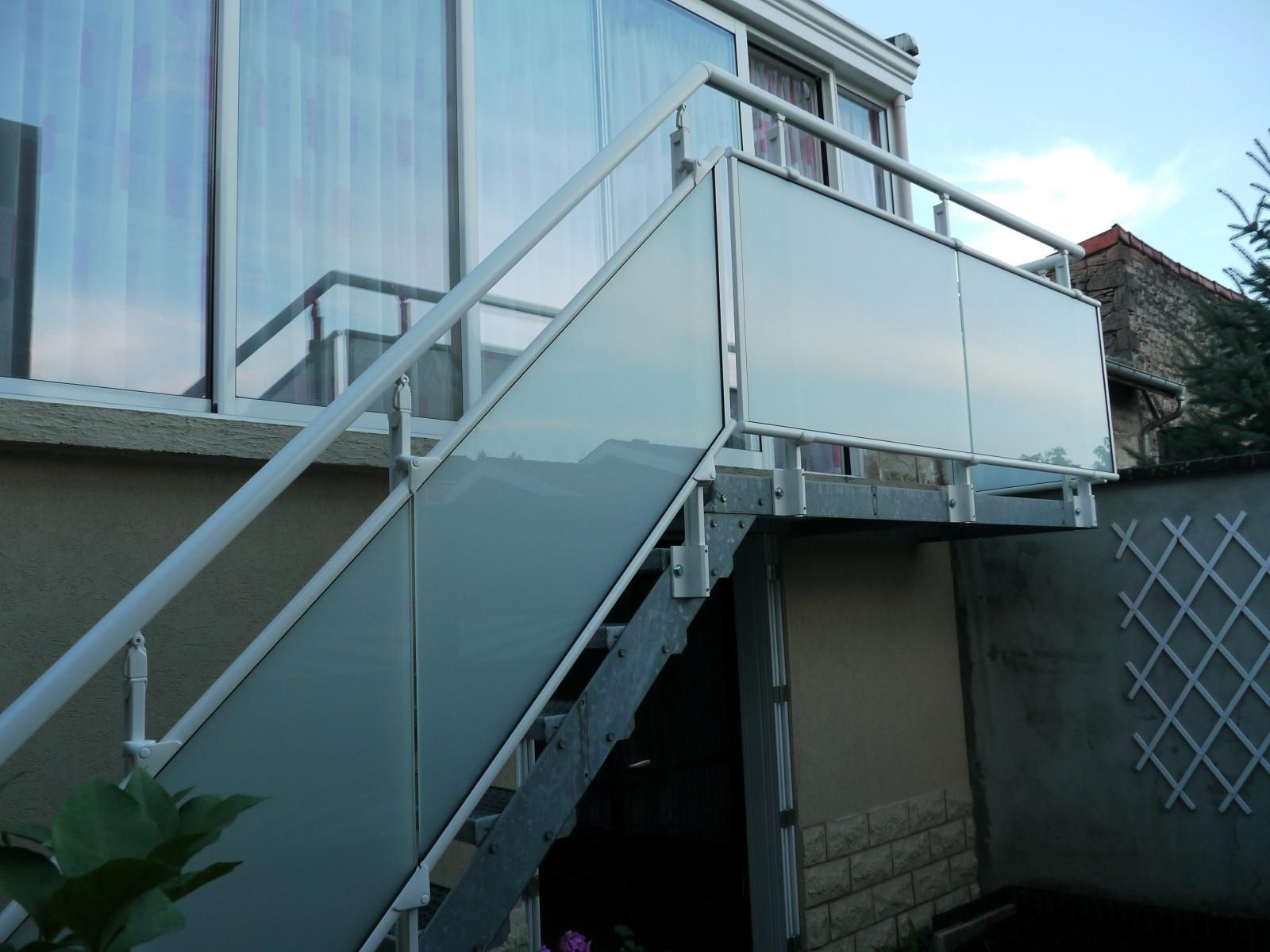 Escalier extérieur en métal avec panneaux de verre.