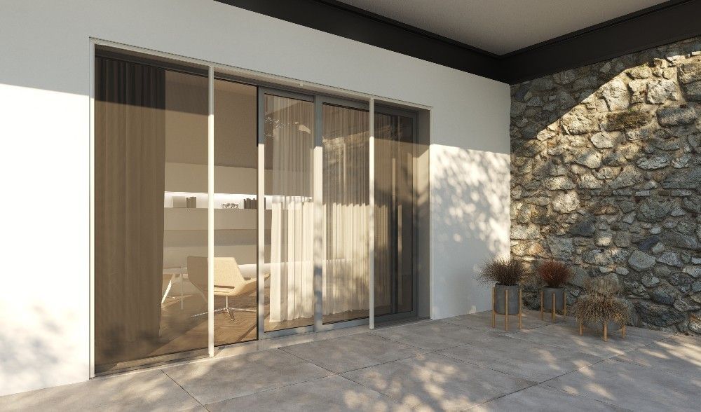 Vue extérieure d'un bâtiment moderne avec des portes coulissantes en verre, des rideaux légers et un mur en pierre.