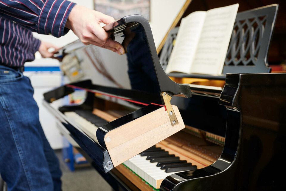 Adrian Heß arbeitet an einem Klavier, Foto von Harald Schlecker