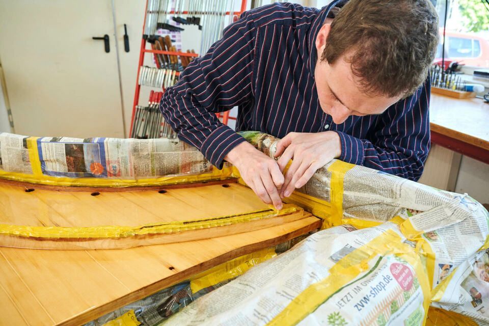 Adrian Heß arbeitet an einem Klavier, Foto von Harald Schlecker