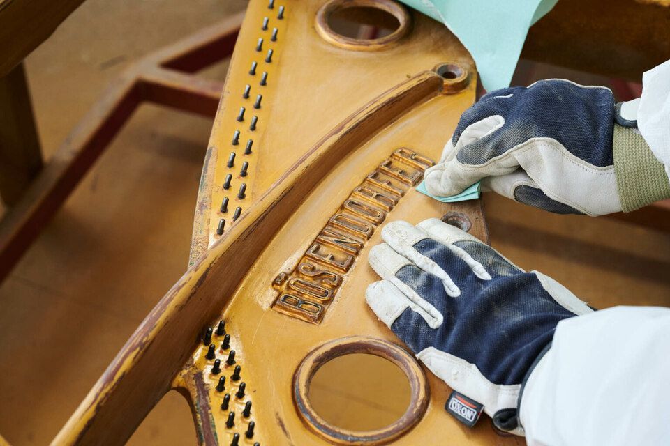 Adrian Heß arbeitet an einem Klavier, Foto von Harald Schlecker