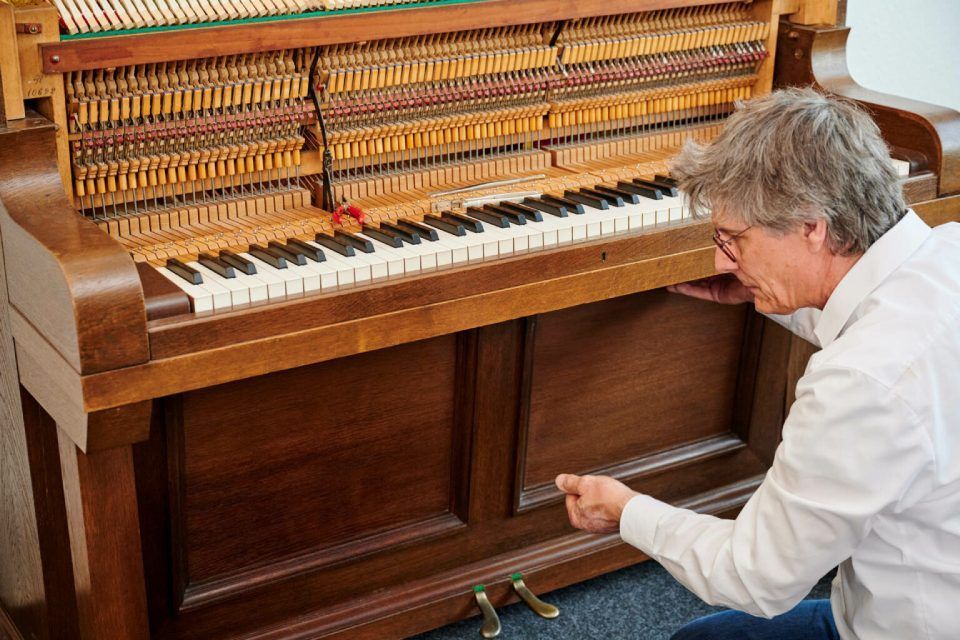 Harald Schlecker begutachtet ein Klavier