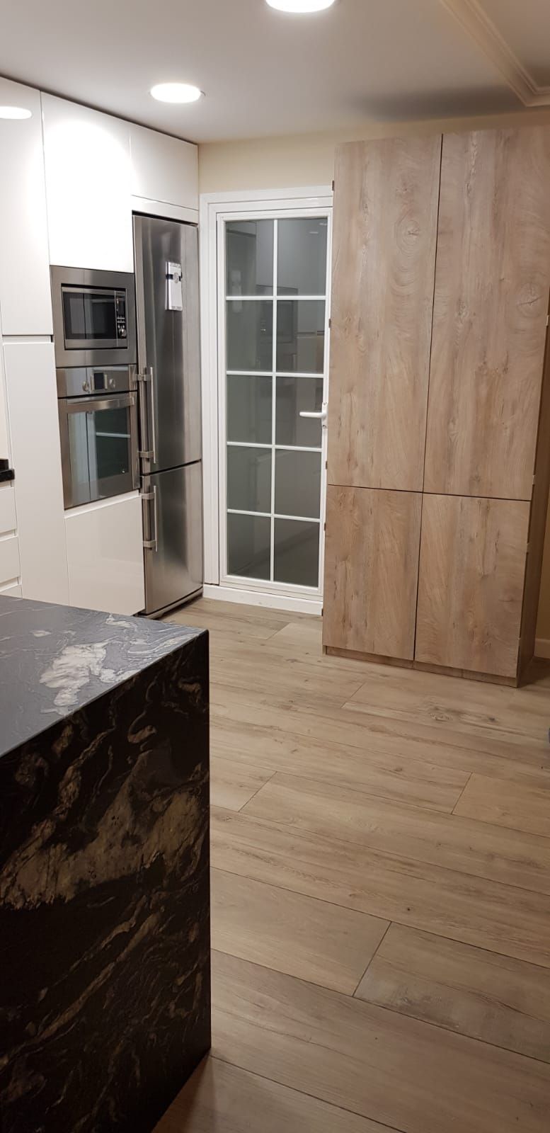 Una cocina con electrodomésticos de acero inoxidable y gabinetes de madera.