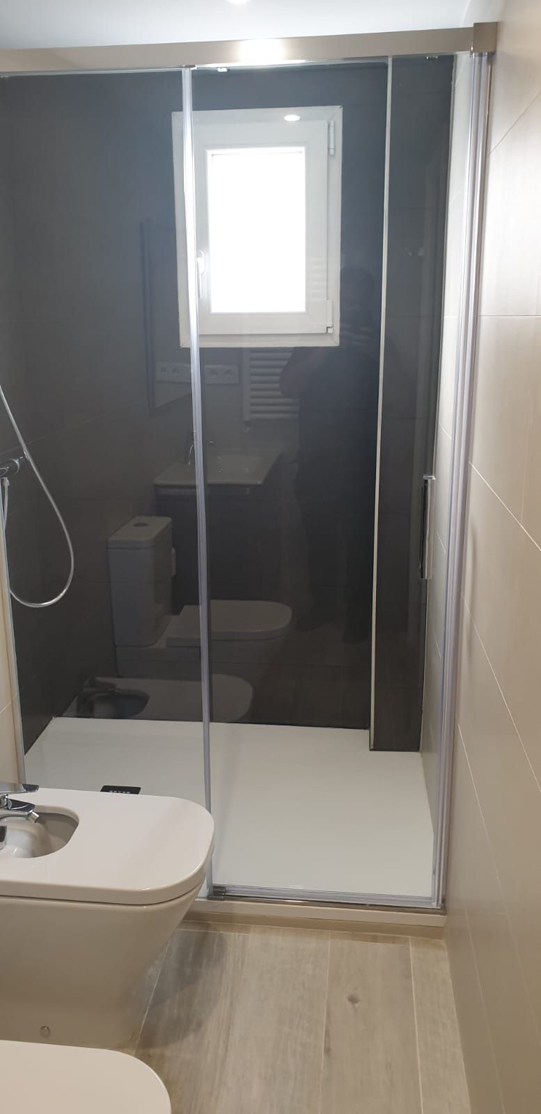 Un baño con inodoro, lavabo y ducha.