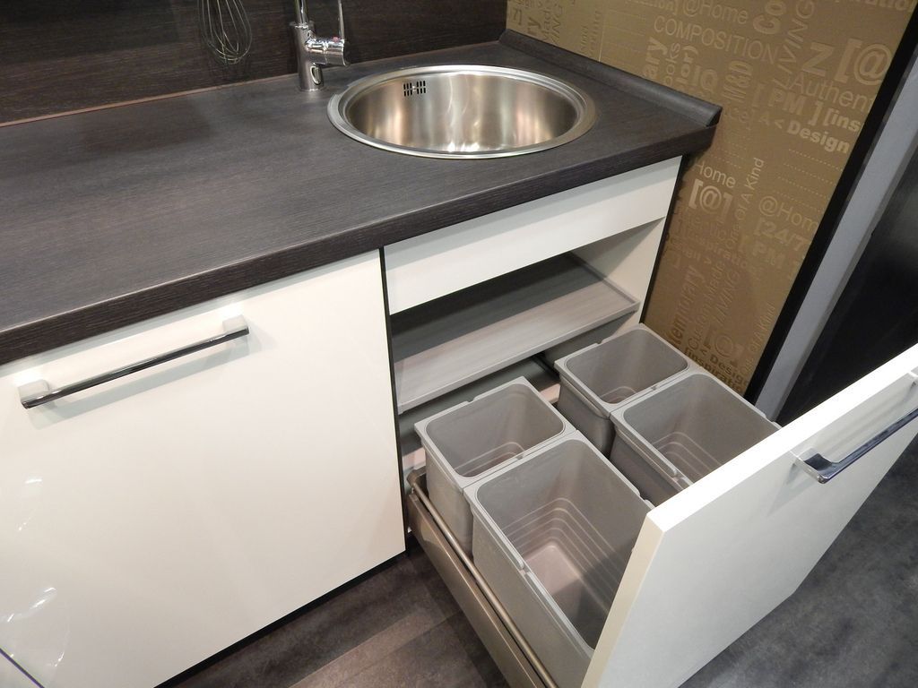 Una encimera de cocina con fregadero y cajones abiertos.