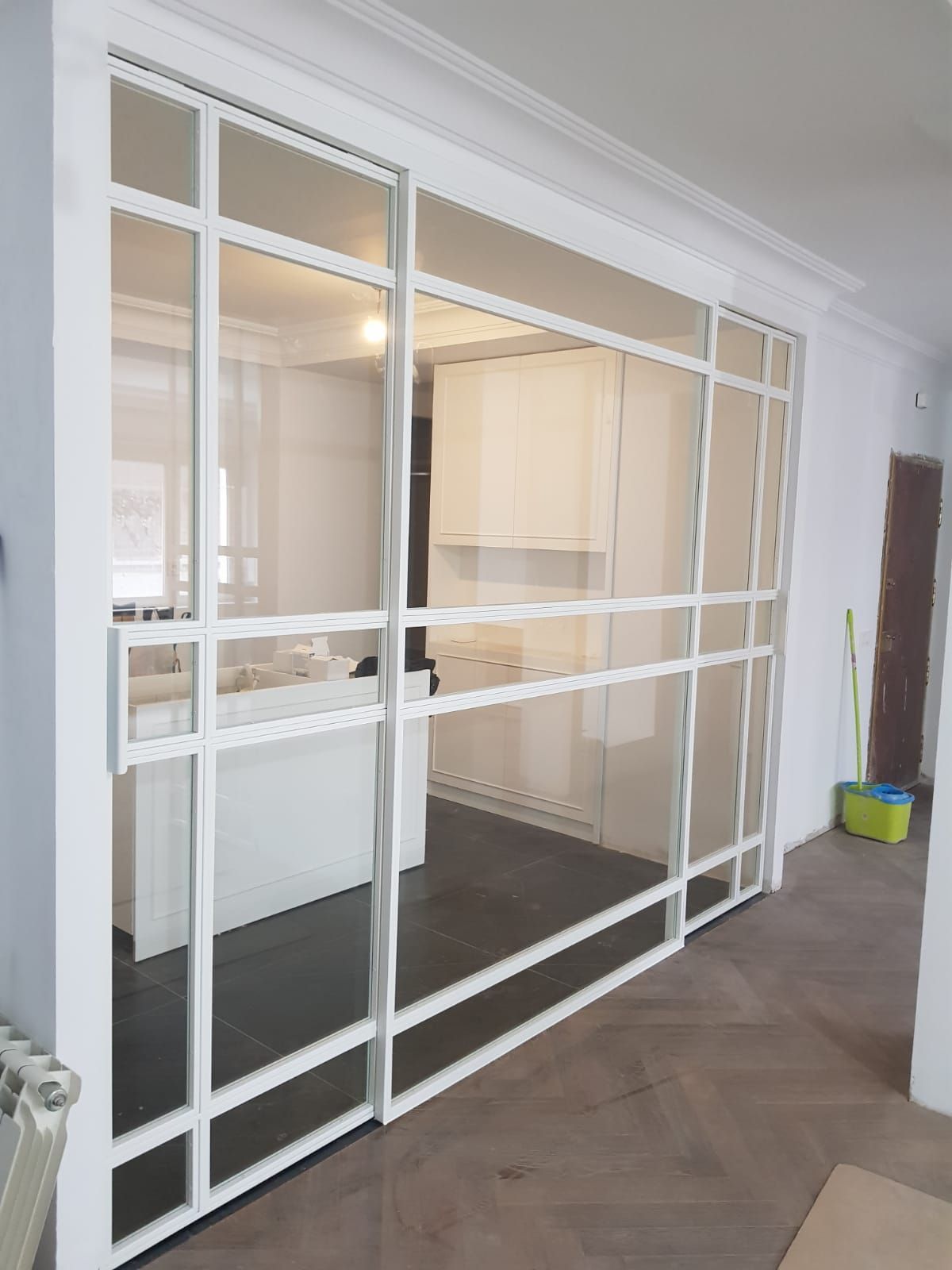 Una sala de estar con puertas corredizas de vidrio que conducen a una cocina.