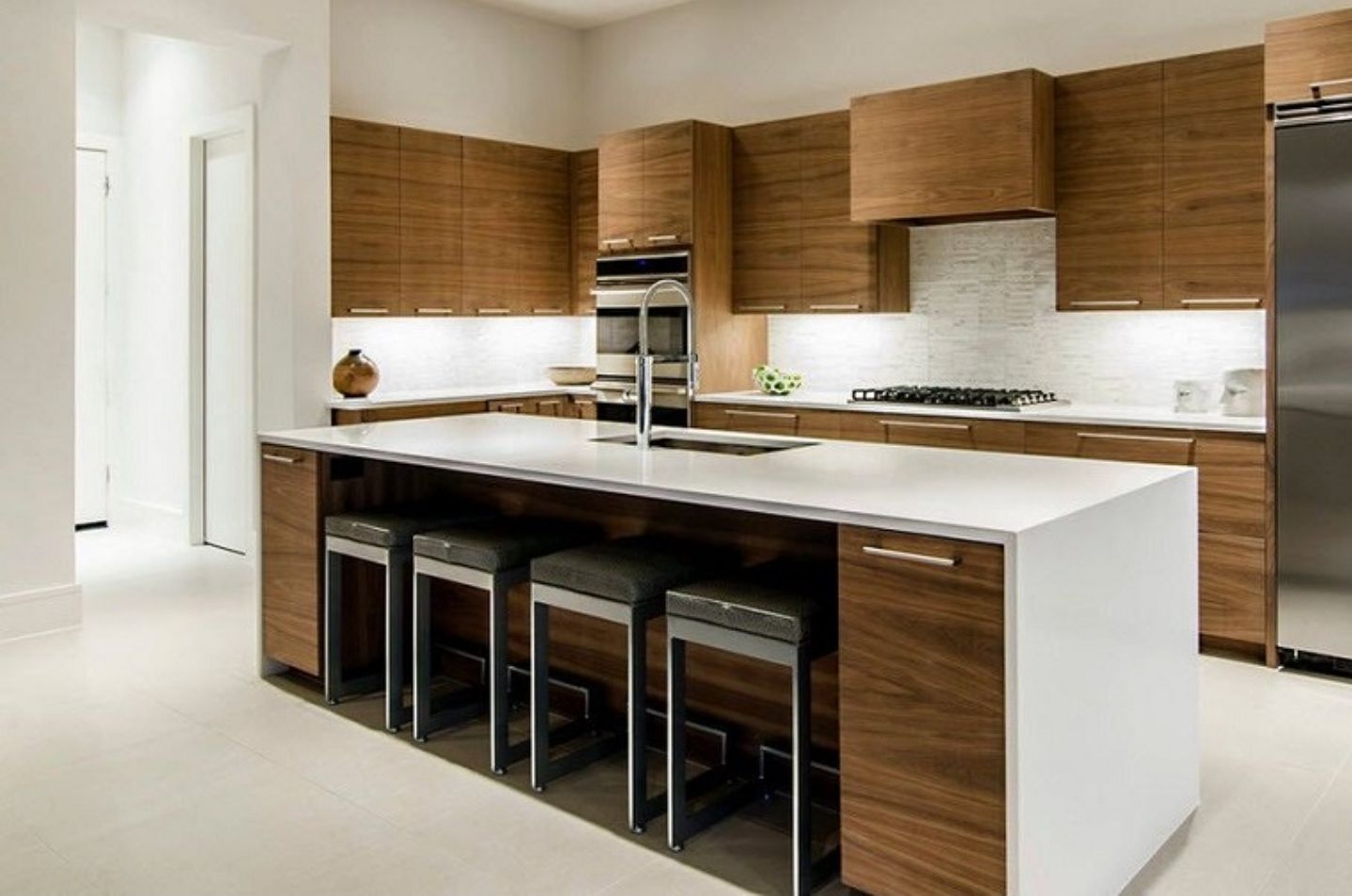 Una cocina con una gran isla y taburetes.