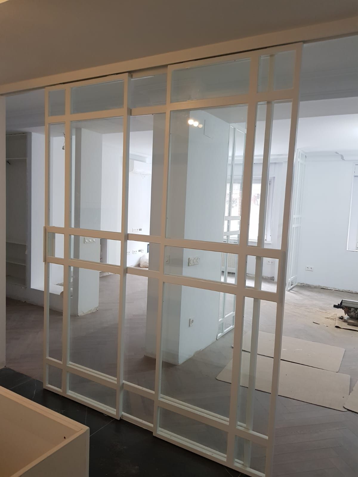 Una habitación con una puerta corrediza de vidrio entre dos habitaciones.