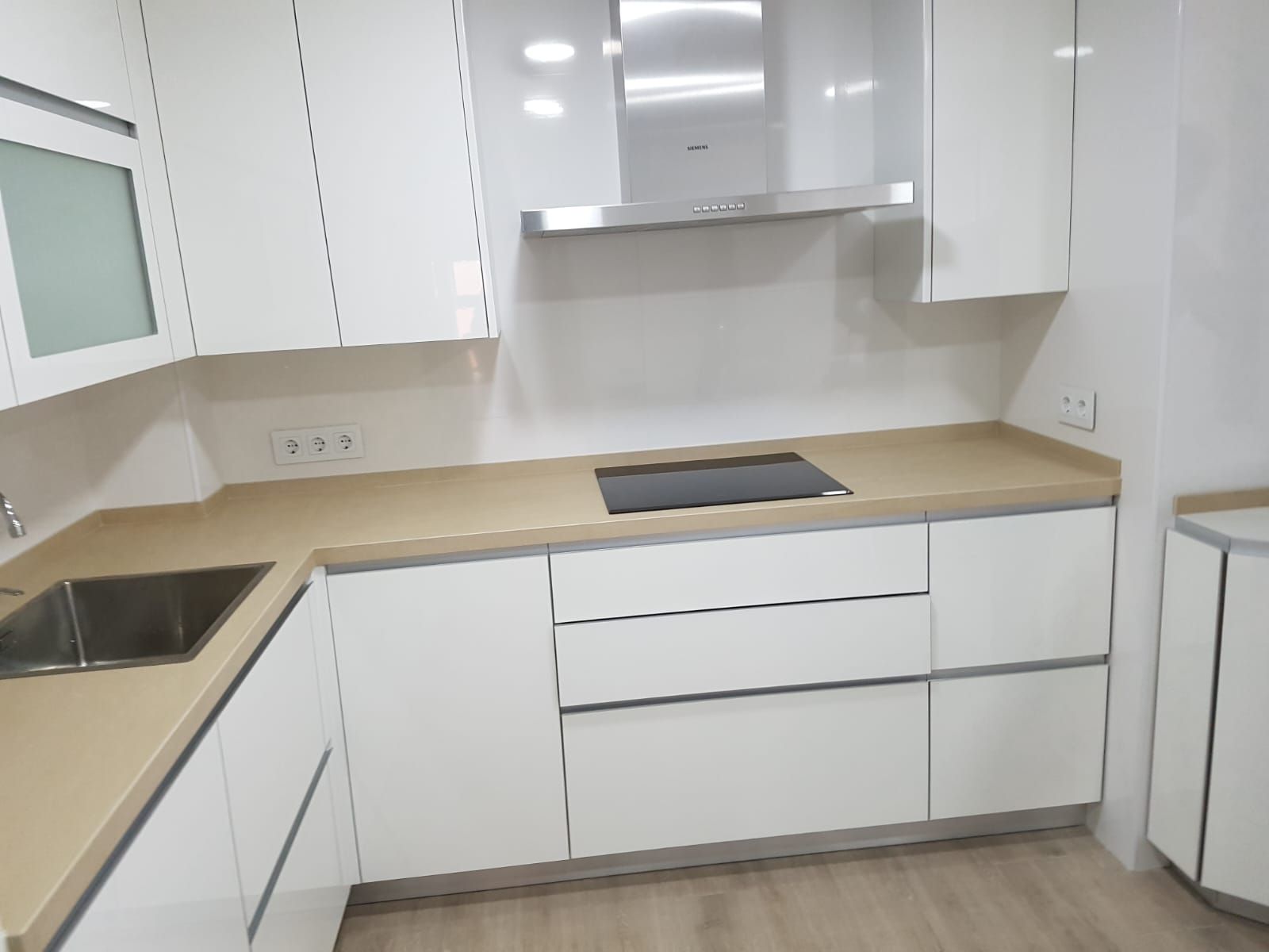 Una cocina con gabinetes blancos y un horno de estufa.