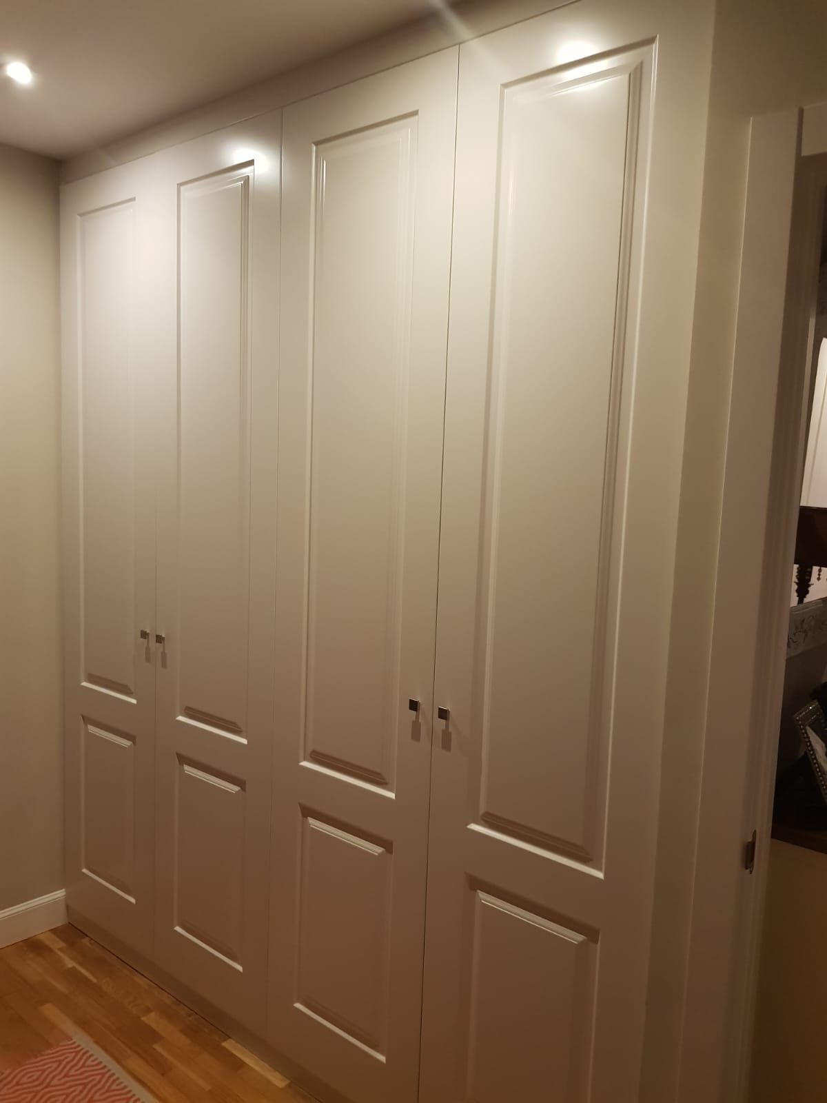 Una habitación con muchos gabinetes blancos en la pared.