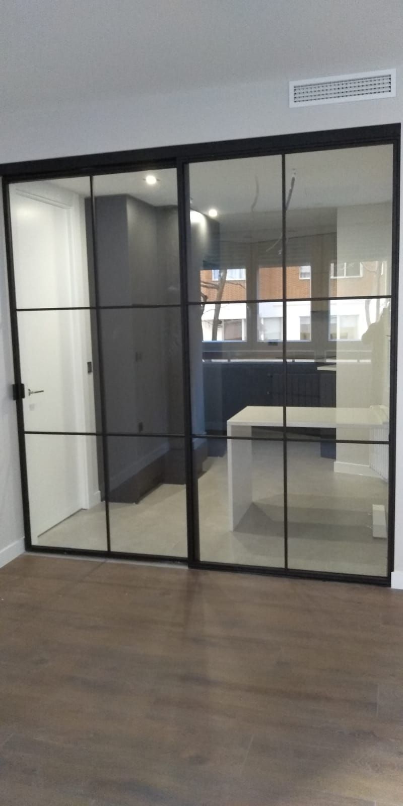 Una habitación con puertas corredizas de vidrio que conducen a una cocina.