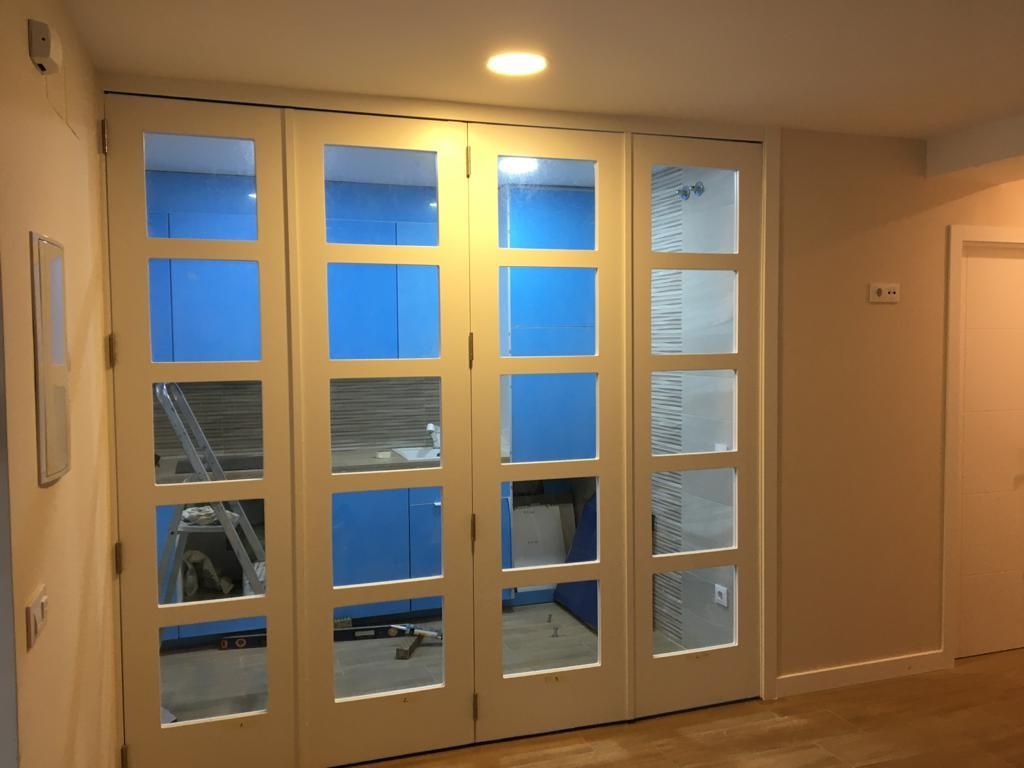 Una habitación con muchas ventanas y una escalera.