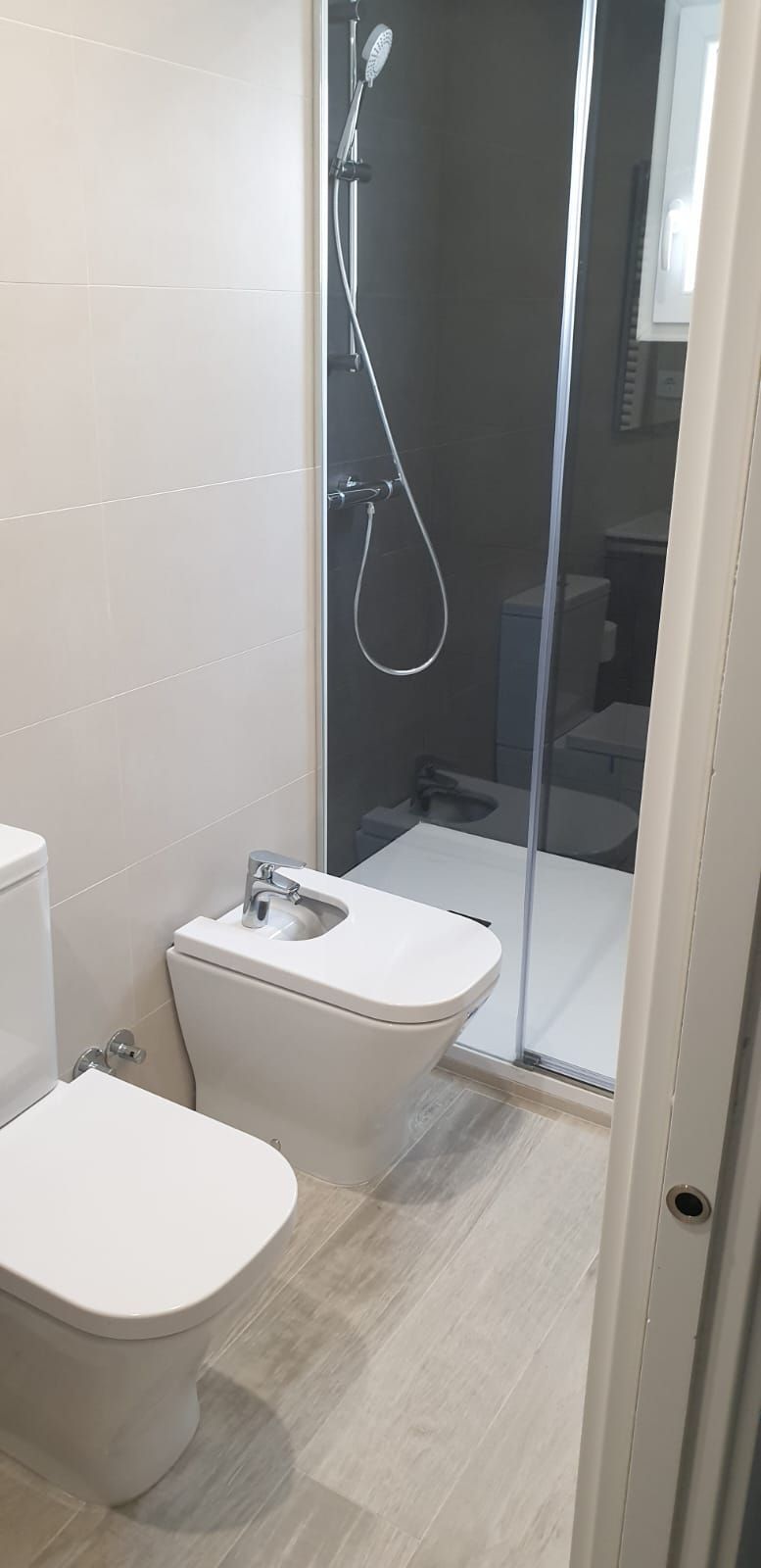 Un baño con inodoro, bidet y ducha.