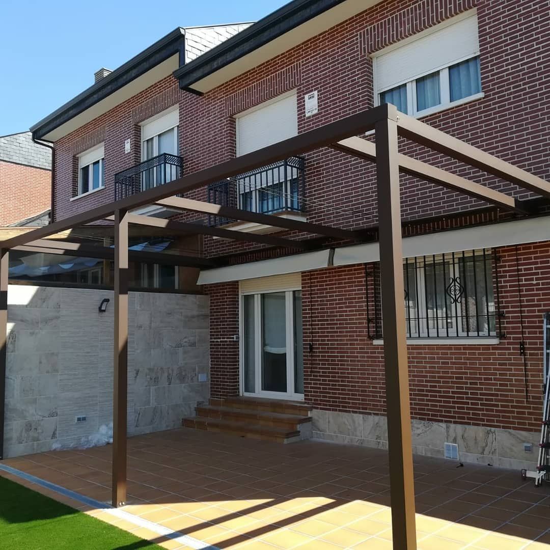 Una casa de ladrillo con una pérgola delante.