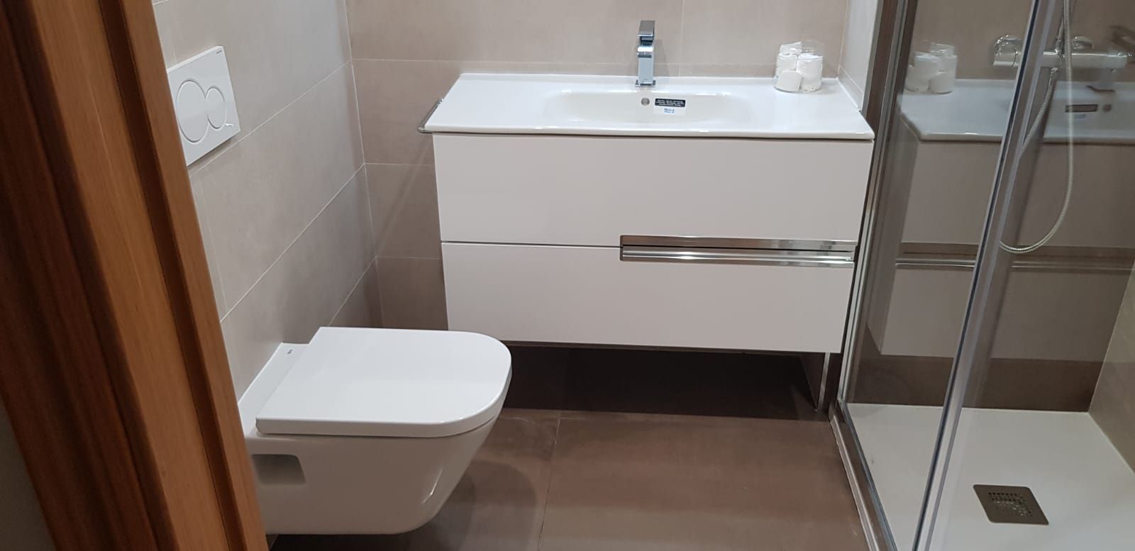 Un baño con inodoro, lavabo y ducha.