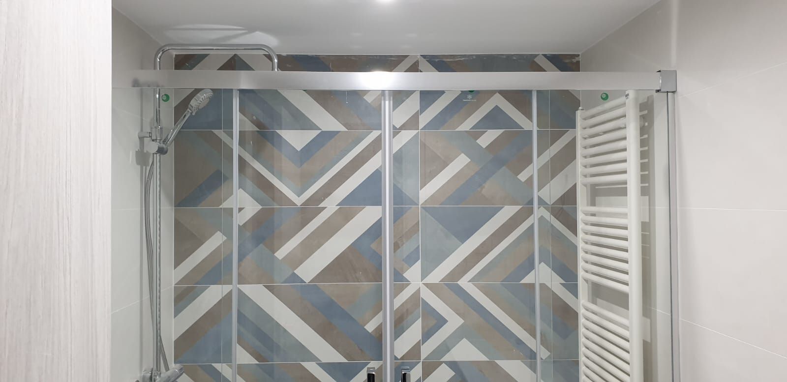 Un baño con cabina de ducha y toallero.