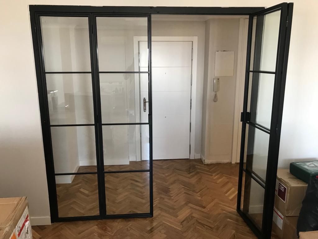 Una habitación con puertas corredizas de vidrio y piso de madera.