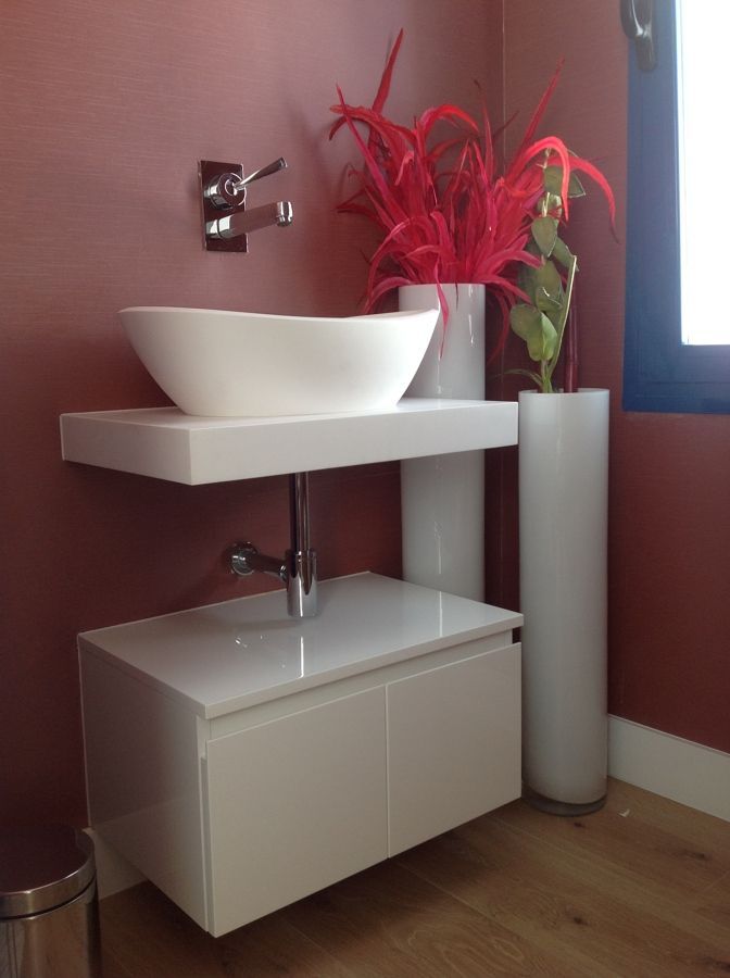 Un baño con un lavabo y un jarrón de flores.