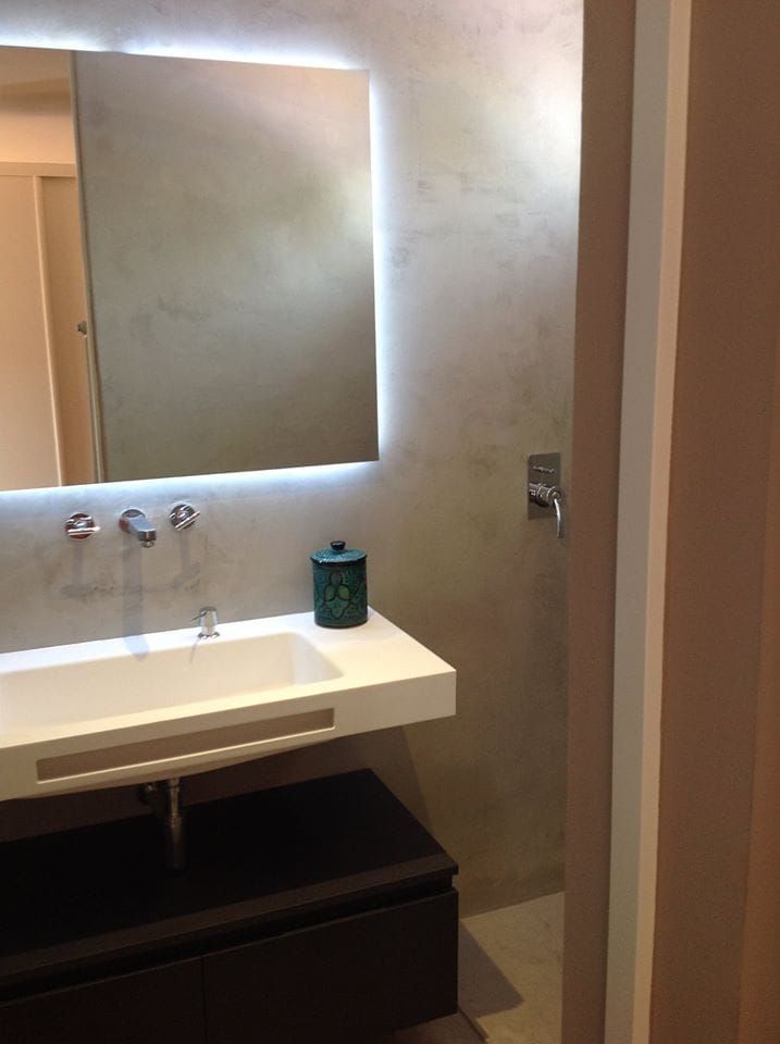 Un baño con un lavabo y un espejo en la pared.