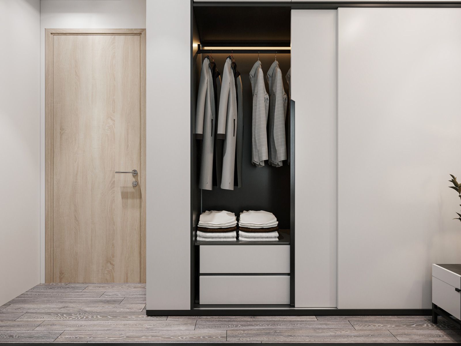 Minimal bedroom closet with hanging shirts, folded towels, and drawers beside a light wood door