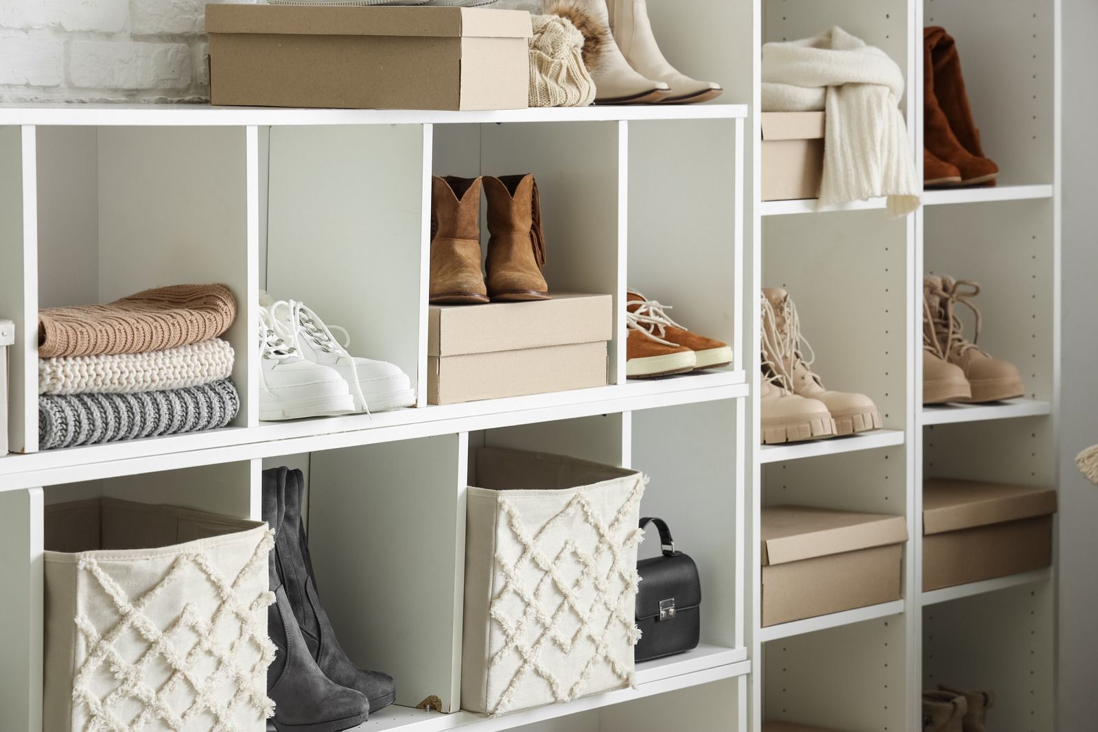 White cube shelves with folded clothes, shoes, and storage baskets in a tidy closet