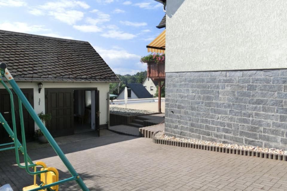 Henkler Garten- und Landschaftsbau - Hof eines Einfamilienhauses mit Garage