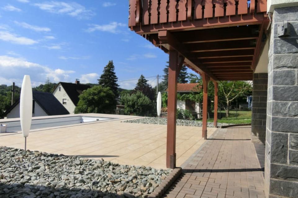 Henkler Garten- und Landschaftsbau - Gepflegte Terrasse mit Holzboden und Schotterbeet