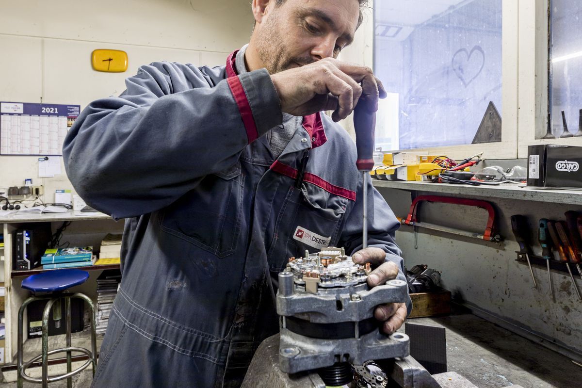 Un technicien démontant une pièce de machine industrielle.