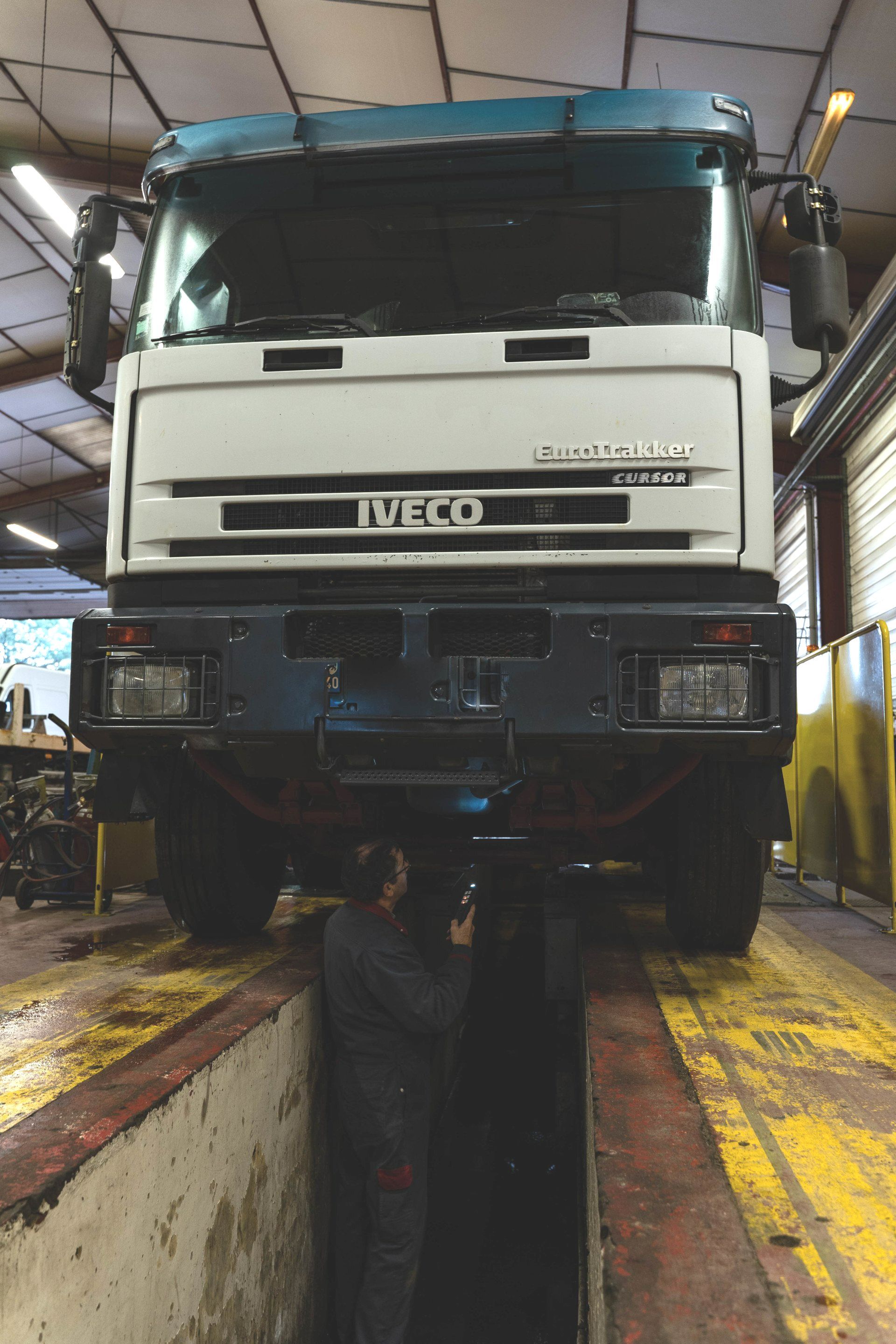 Un mécanicien dans une fosse sous un camion en réparation.