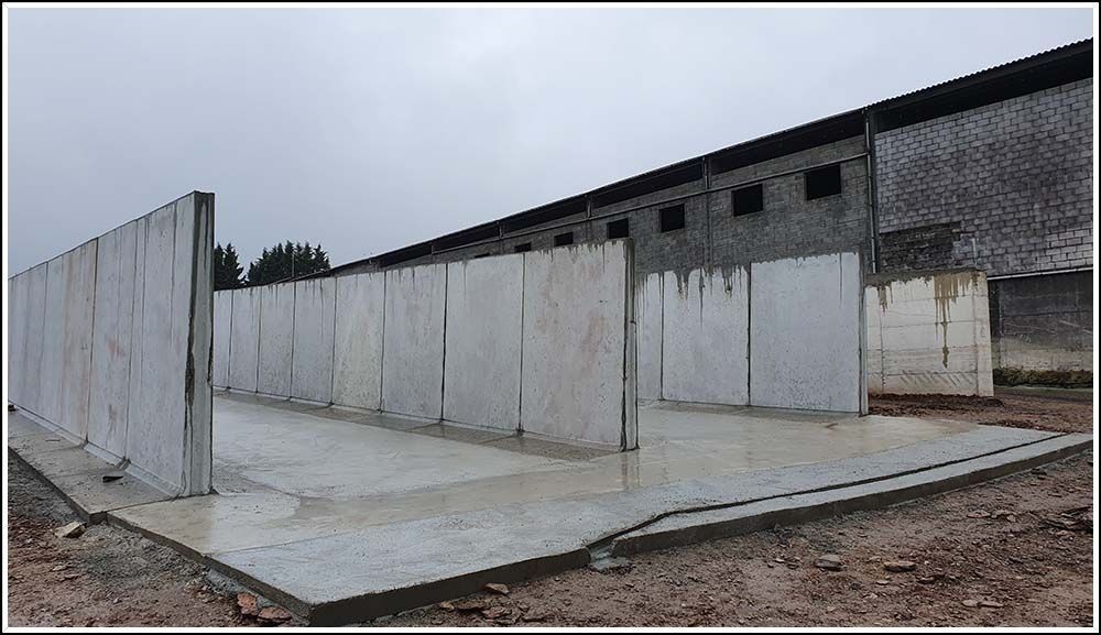 Se está construyendo un muro de hormigón delante de un edificio.