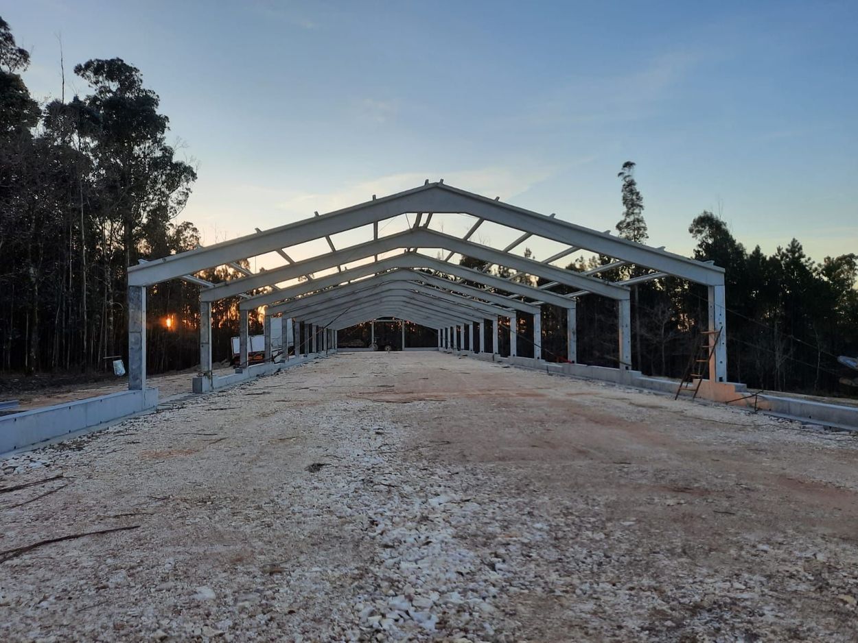 Se está construyendo una gran estructura metálica en medio de un campo de tierra.
