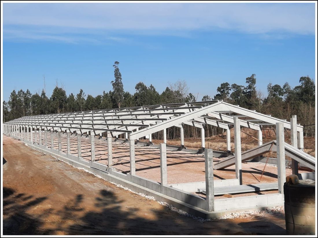 Se está construyendo una gran estructura metálica en medio de un camino de tierra.