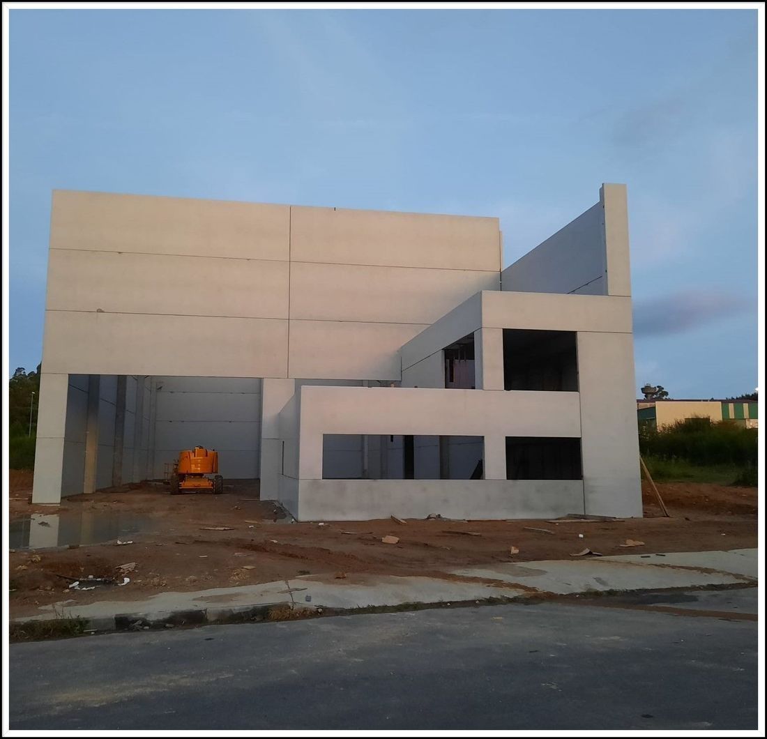 Se está construyendo un gran edificio blanco al costado de la carretera.