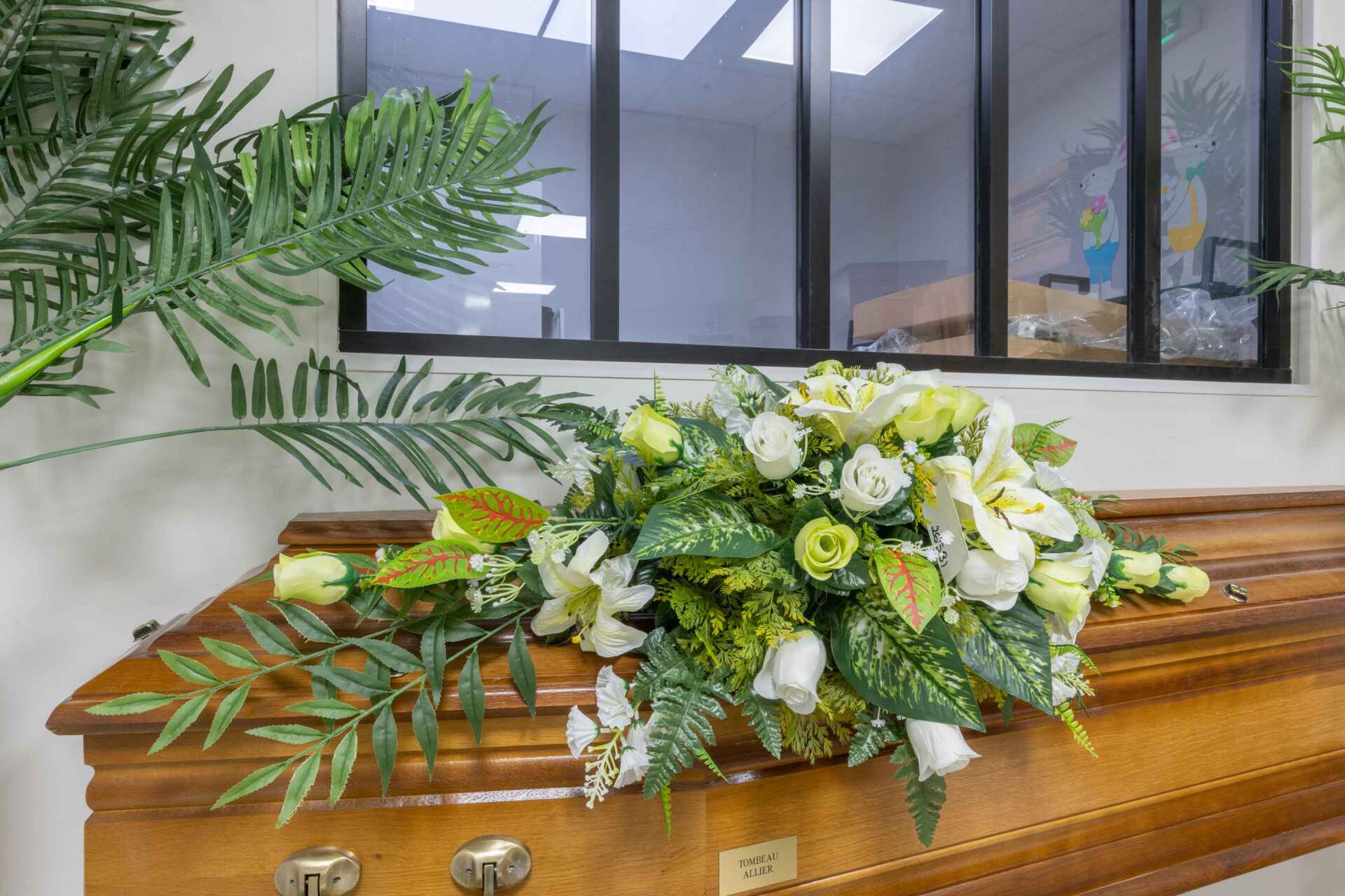 Bouquet de fleurs blanches et vertes sur cercueil