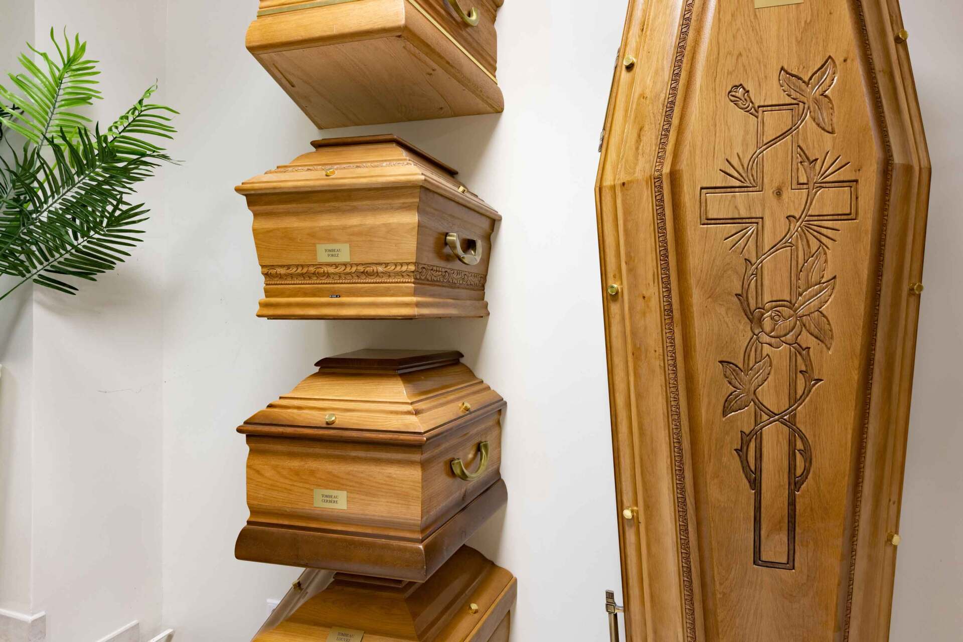 Présentation de différents cercueils en bois gravés