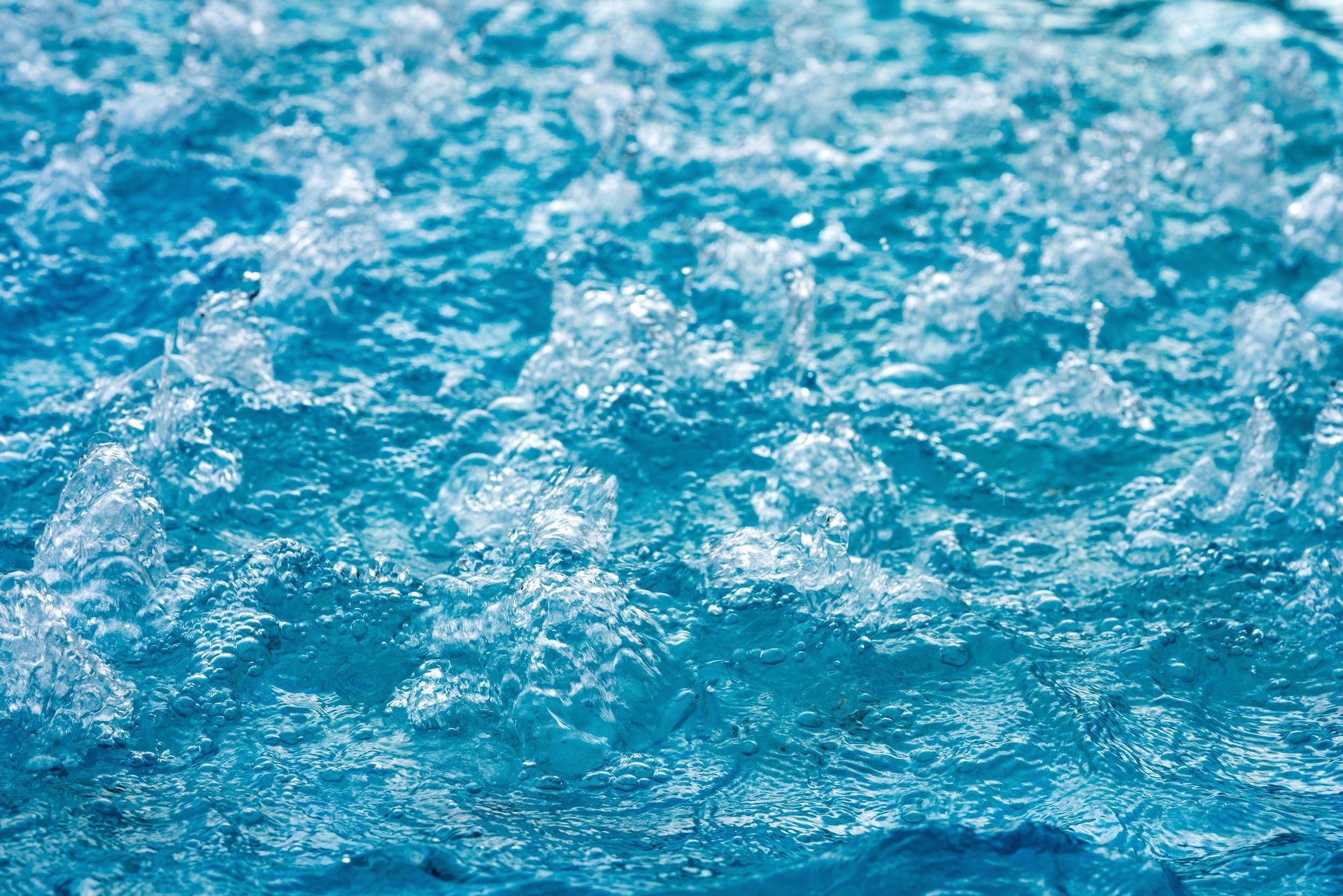 Un gros plan d'une piscine d'eau avec des bulles qui en sortent.