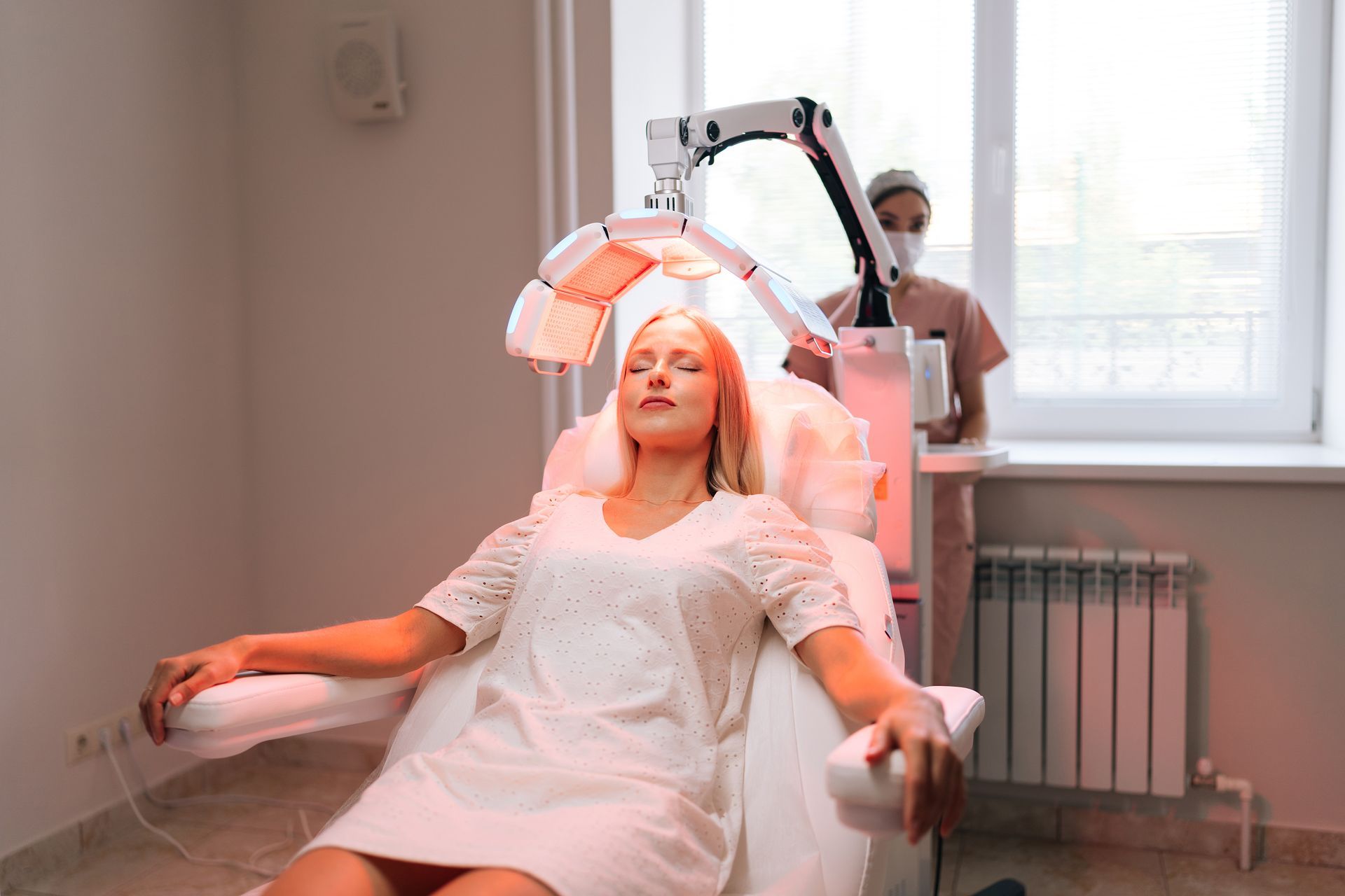 Une femme est assise sur une chaise, les yeux fermés, dans un salon de beauté.