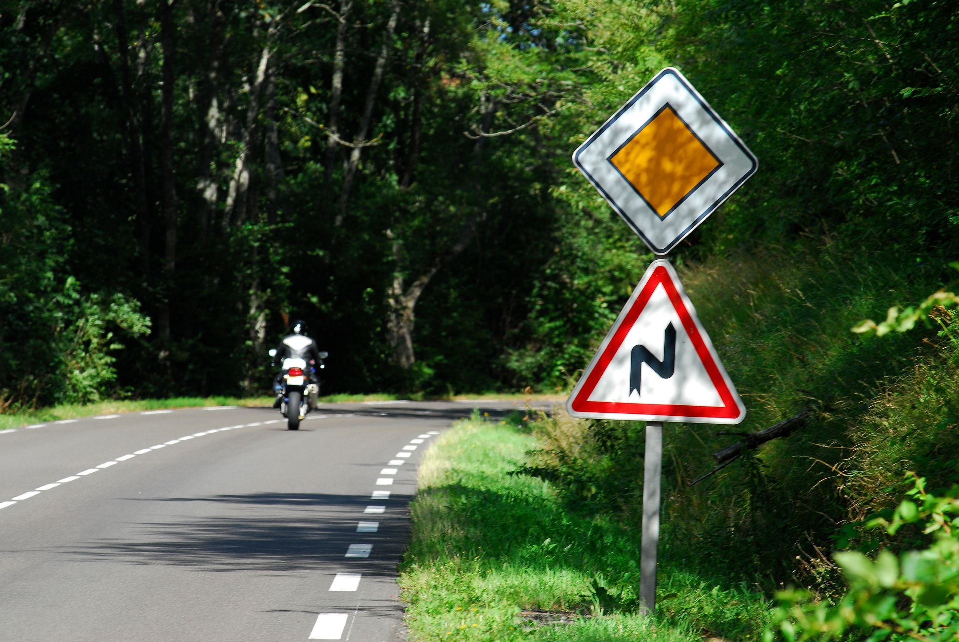 Motard sur une route de campagne avec un virage