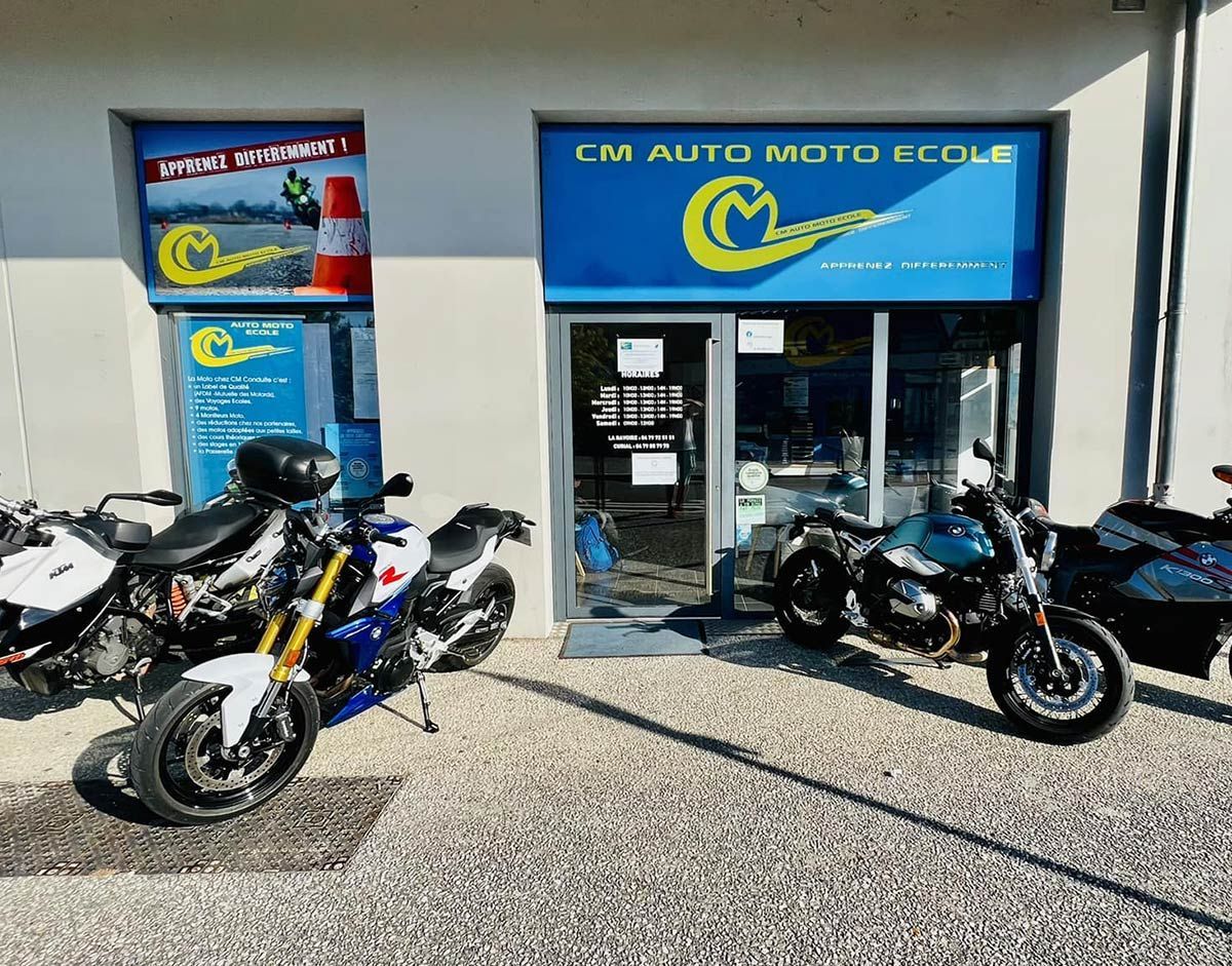 Des motos garées devant CM AUTO-ÉCOLE