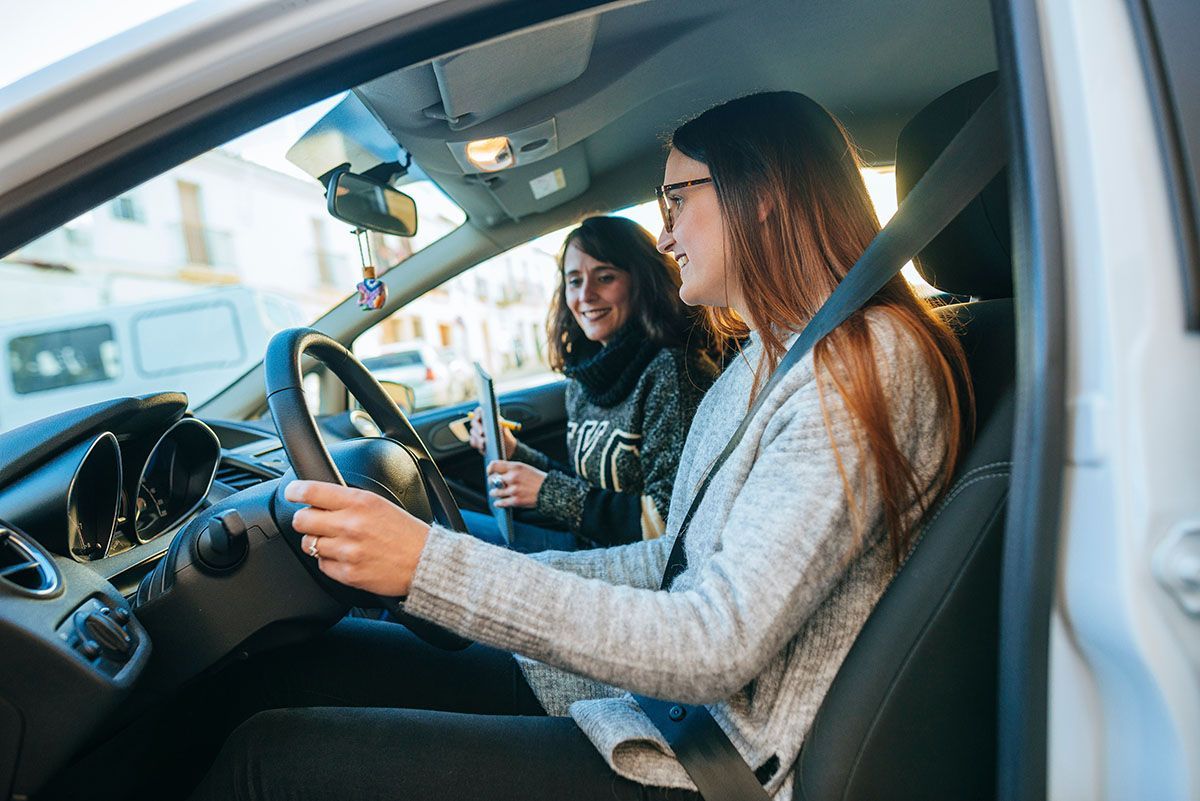 Une monitrice d'auto-école apprenant la conduite à une jeune femme