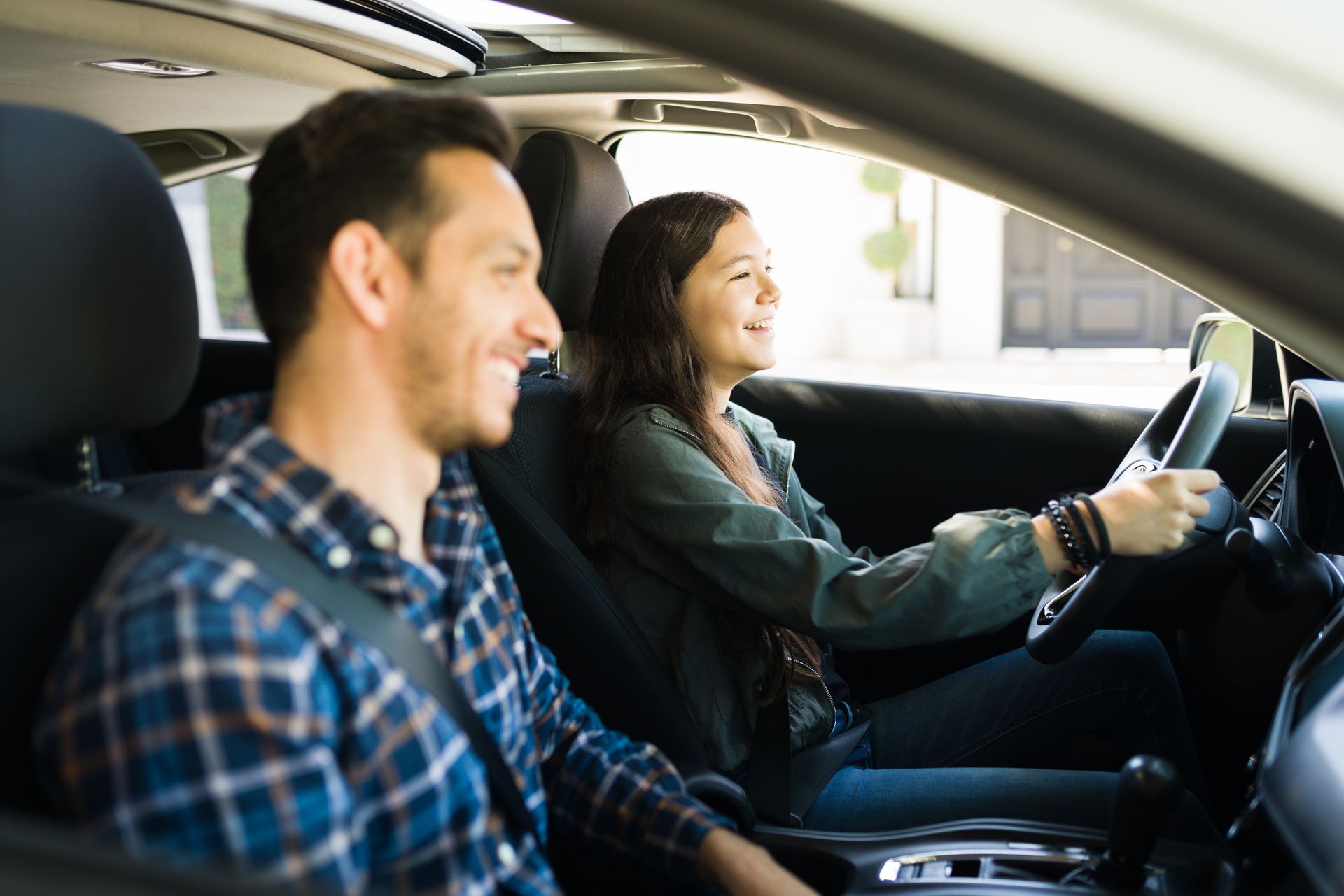 Un instructeur de conduite et une conductrice qui sourient dans une voiture