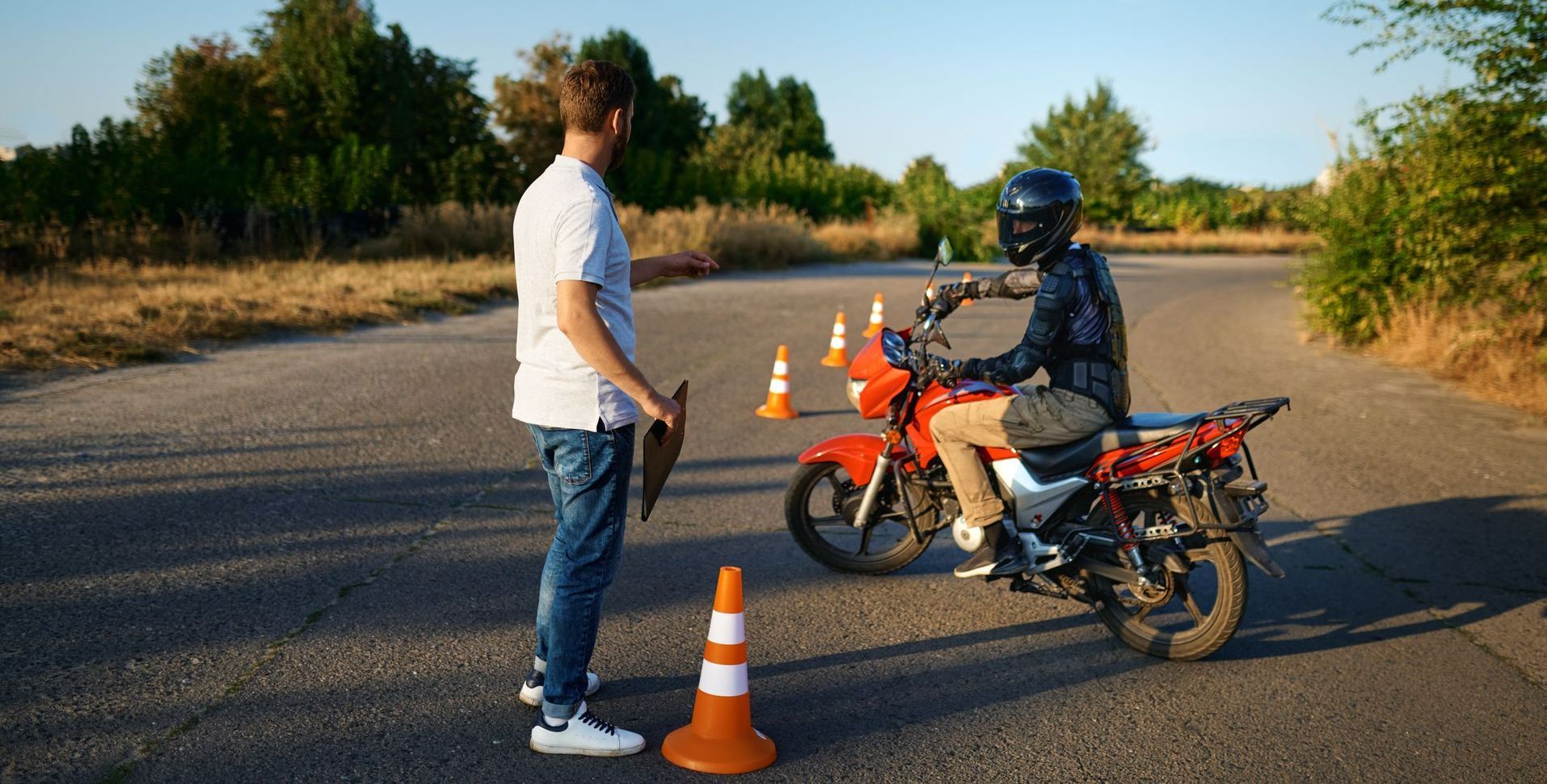Un instructeur d'auto-école explique un parcours à un motard