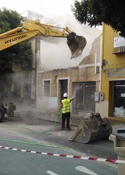 Una excavadora amarilla Hyundai está demoliendo un edificio.